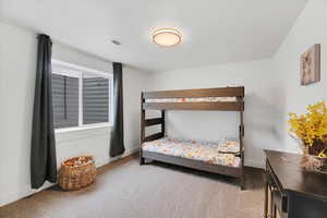 Carpeted bedroom with baseboards and visible vents