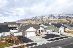 View of front of property featuring a mountain view, driveway, an attached garage, and a residential view