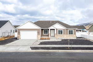 Single story home with a mountain view, a garage, fence, driveway, and roof with shingles