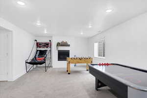 Recreation room featuring recessed lighting, visible vents, a large fireplace, light carpet, and baseboards