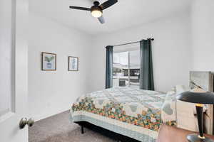 Carpeted bedroom featuring a ceiling fan and baseboards