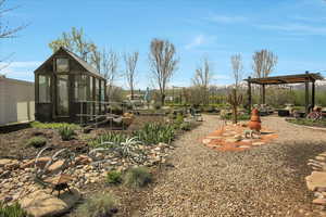 View of yard with an outdoor structure, a greenhouse, and a garden