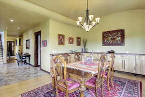 Dining area with light wood-type flooring, baseboards, a notable chandelier, and recessed lighting