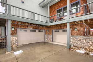 View of side of property with a garage, stone siding, and driveway