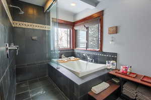 Bathroom with tile patterned flooring, a tile shower, and a bath