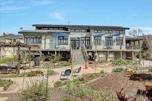 Rear view of property featuring stairway, a wooden deck, and a pergola