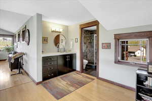 Bathroom with plenty of natural light, a shower stall, toilet, and wood finished floors