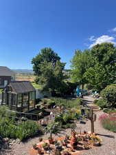 View of yard featuring a mountain view, an outbuilding, an exterior structure, and a garden