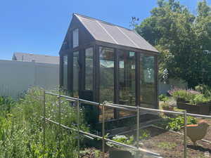 View of greenhouse featuring fence