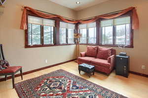 Living room with light wood finished floors, recessed lighting, and baseboards