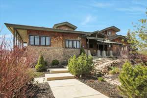 Chalet / cabin featuring covered porch and stone siding