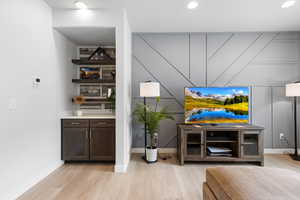 Bar with light wood-type flooring, baseboards, and recessed lighting