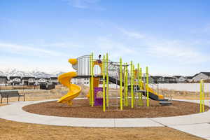 Community jungle gym featuring a residential view and fence