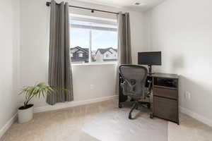 Carpeted office space with visible vents and baseboards