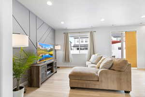 Living area with light wood-type flooring, baseboards, and recessed lighting