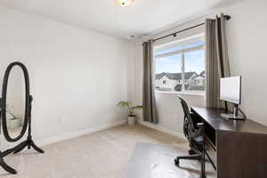 Office with light carpet, visible vents, and baseboards