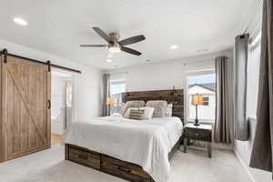 Bedroom with light carpet, a barn door, visible vents, and recessed lighting