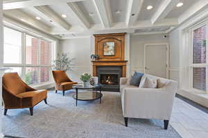 Sitting room featuring light tile patterned floors, ornamental molding, a fireplace, and beam ceiling