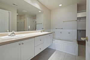 Full bathroom featuring double vanity, tile patterned flooring, visible vents, and a sink