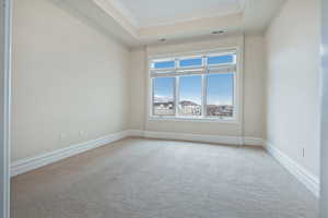 Unfurnished room with baseboards, visible vents, ornamental molding, and a tray ceiling