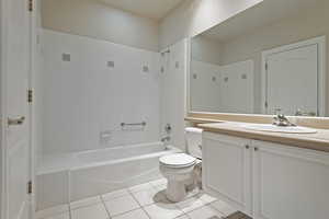 Full bath featuring shower / washtub combination, vanity, toilet, and tile patterned floors