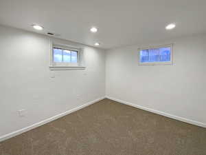 Below grade area featuring carpet floors, baseboards, visible vents, and recessed lighting