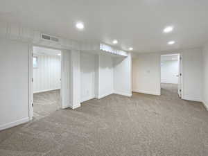 Finished basement featuring carpet floors, recessed lighting, and visible vents