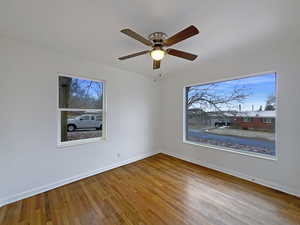 Unfurnished room featuring ceiling fan, baseboards, and wood finished floors