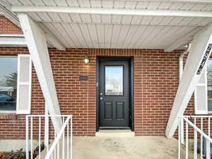 View of exterior entry with brick siding