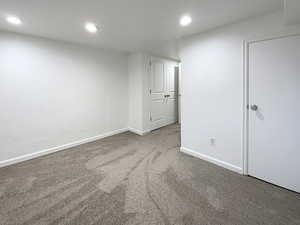 Spare room with recessed lighting, light colored carpet, and baseboards