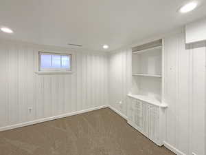 Interior space with baseboards, dark colored carpet, and recessed lighting