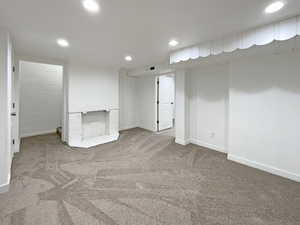 Unfurnished room with recessed lighting, a fireplace, carpet flooring, visible vents, and baseboards