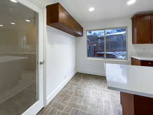 Interior space featuring light countertops, recessed lighting, stone finish flooring, and baseboards