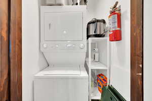 Washroom with stacked washer and dryer and laundry area