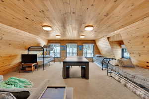 Playroom with carpet floors, wood ceiling, and wooden walls