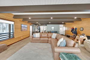 Living room with wood walls and beamed ceiling