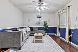 Living room, wood-type flooring, Wainscoting, glass slider to patio