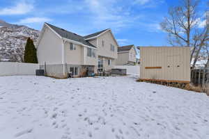 Fully fenced backyard with sprinklers, huge storage shed, patio, and hot tub, and mountain views