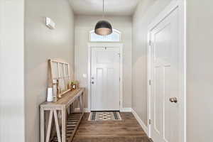 Foyer entrance featuring dark wood-style floors and baseboards