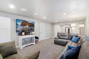 Living area with a barn door, carpet, recessed lighting, and baseboards