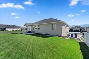 Rear view of house with a residential view, a lawn, fence, and stucco siding