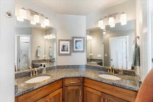 Bathroom with double vanity, a sink, and a shower with door