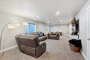 Living room with recessed lighting, light colored carpet, and baseboards