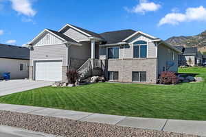 Craftsman inspired home featuring board and batten siding, concrete driveway, brick siding, and a front lawn