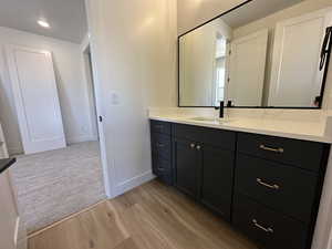 Bathroom featuring vanity, baseboards, and wood finished floors