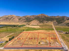 Aerial view of sparsely populated area featuring property parcel outlined and mountains