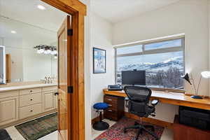 Home office with light tile patterned floors, recessed lighting, a sink, and baseboards