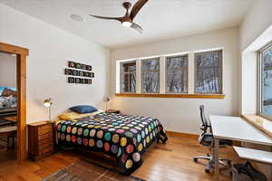 Bedroom featuring ceiling fan, a textured ceiling, baseboards, and wood finished floors