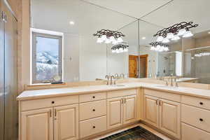 Full bathroom featuring double vanity, a shower stall, a sink, and recessed lighting