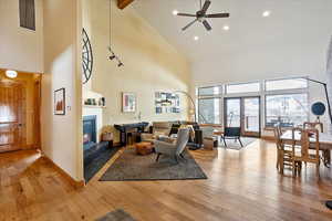 Living area featuring visible vents, a glass covered fireplace, light wood-style flooring, and baseboards